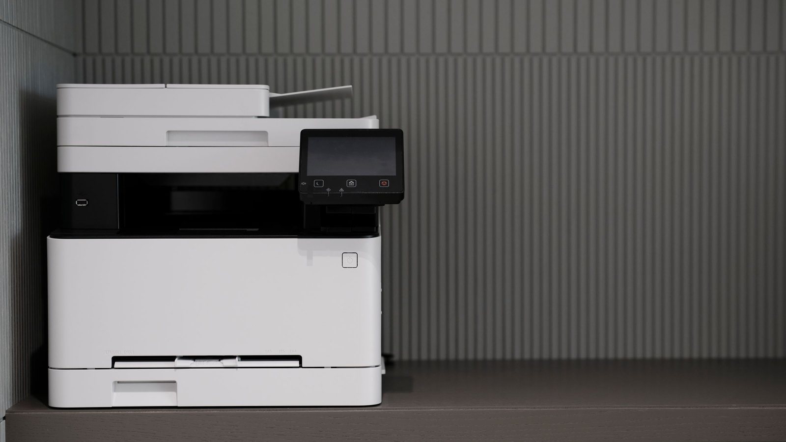 A modern multifunction printer and scanner on an office cabinet