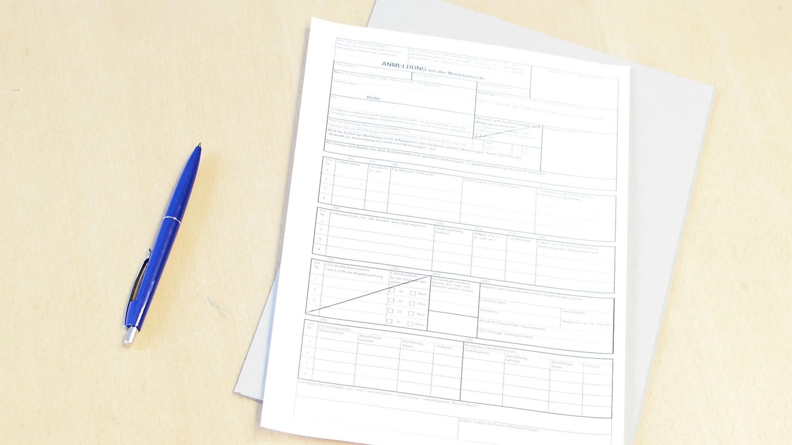 A blank printed registration form and a pen on a plain office table